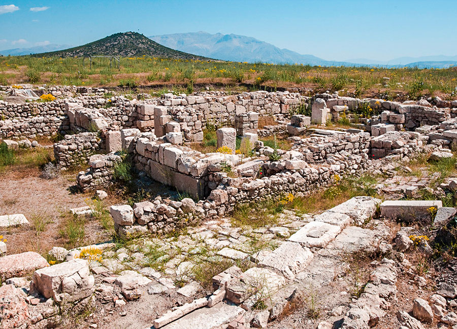The excavation site of Choma Ancient City (Hacımusalar Mound) rising in the middle of the Elmalı Plain and the Byzantine period church ruins.