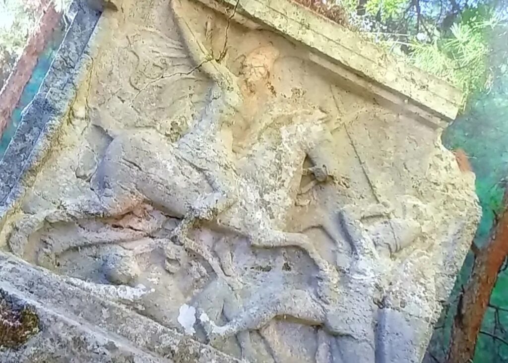 The relieved Rider Tomb Monument of Kadyanda Ancient City hidden among pine trees and the Lycian period fortification remains.