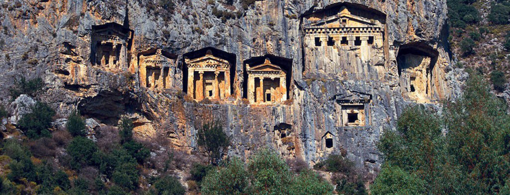 The monumental Lycian-type house tombs carved into vertical and steep cliffs above Kızılkaya Village in Oktapolis Ancient City.